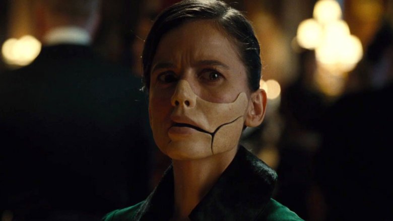 A still from the 2017 film Wonder Woman showing the villainous character Dr. Poison wearing a life-like mask covering her hose, left cheek, and lips. The mask is articulated to allow speech and movement.