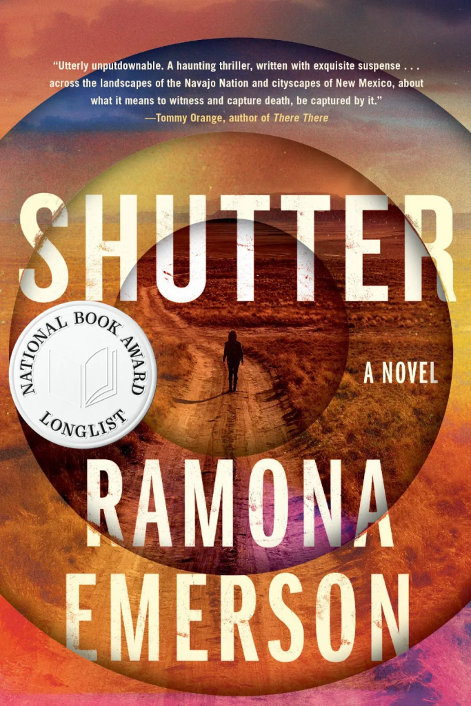 The cover of Ramona Emerson's Shutter, featuring an image of a woman walking down a long dirt road surrounded by desert sagebrush. Concentric circles around the woman suggest camera lenses.