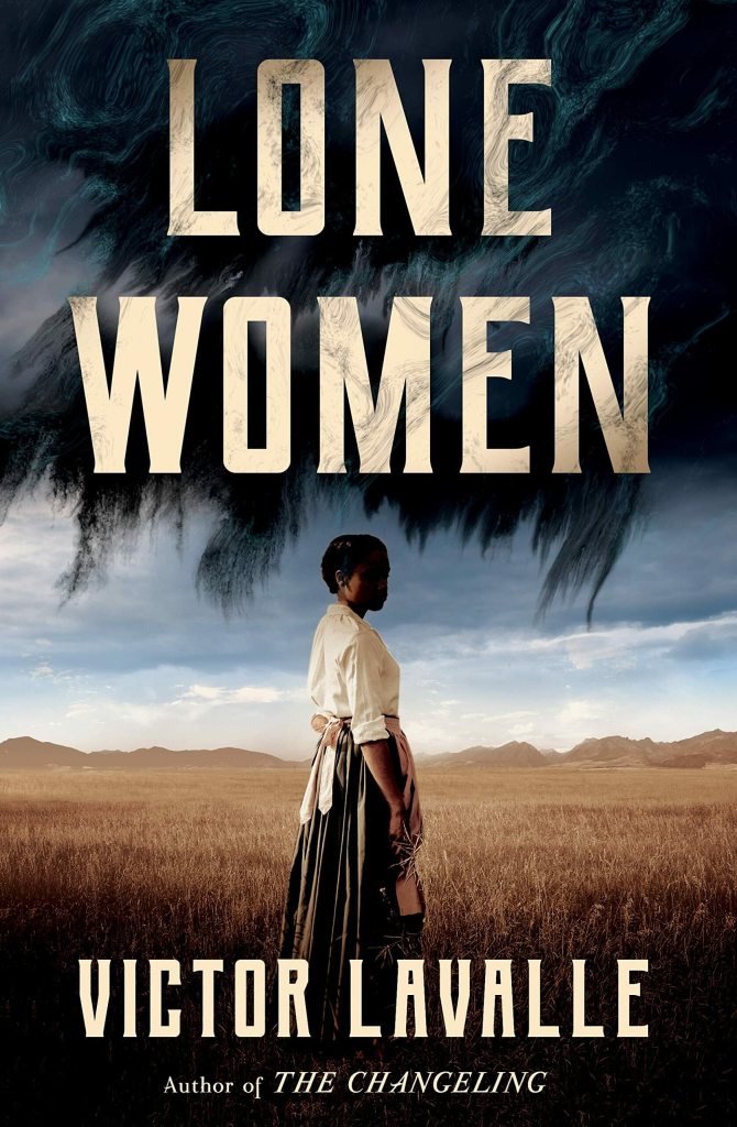 The cover for Lone Women, featuring a Black woman in pioneer-era clothing standing in the middle of a wide field of dried grass or grain. Shadows gather overhead.