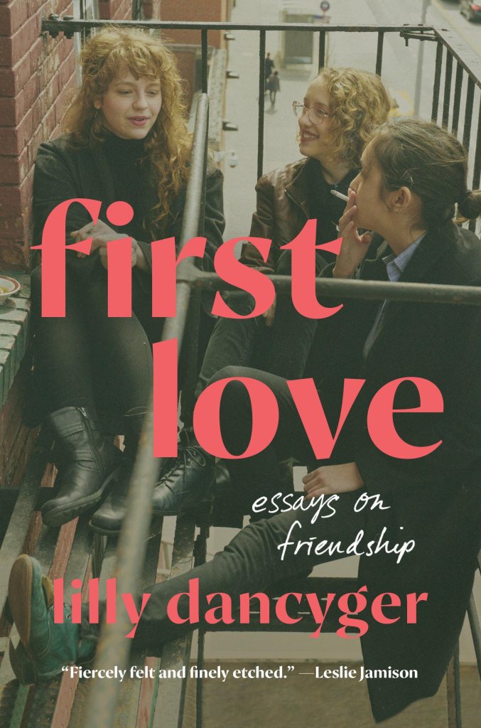 The title of the book (First Love: Essays on Friendship) and author name are superimposed on a photograph of three young fair-skinned girls, one of whom is the author, smoking and laughing on a fire escape.